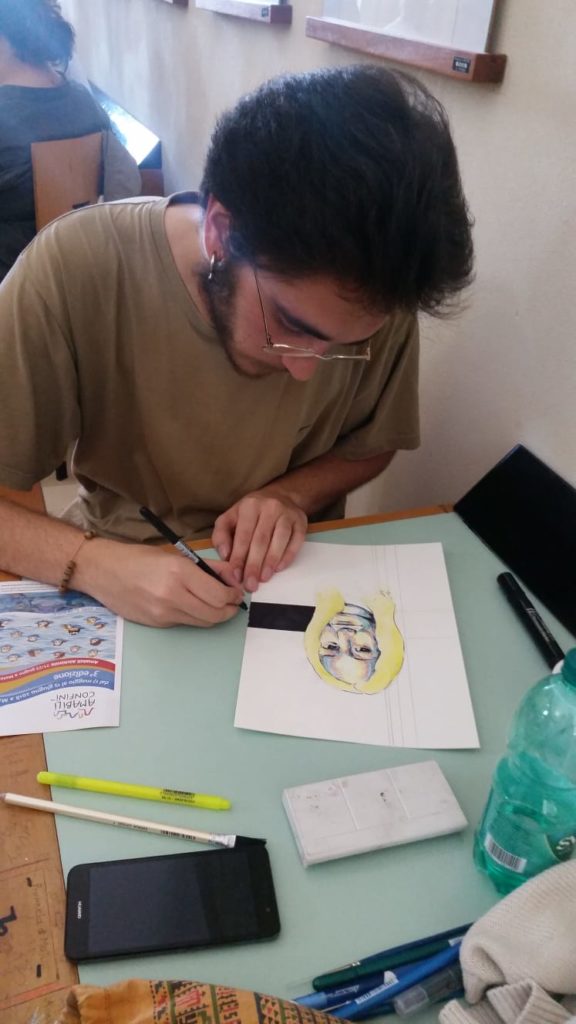 Michele Melodia mentre realizza il disegno donato a Rosella Postorino